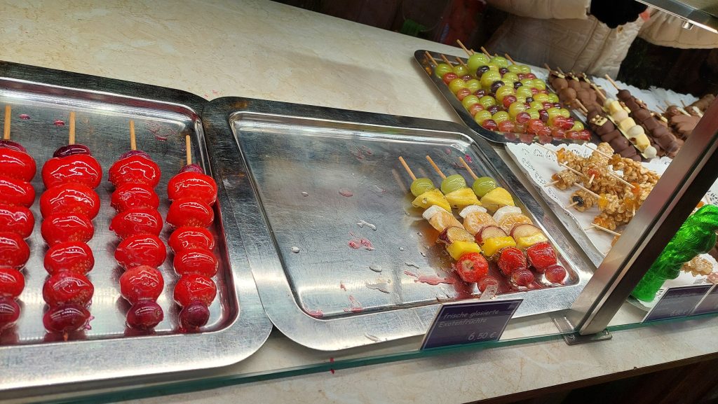Glasierte Früchte (Erdbeeren, Weintrauben, Tropenfrüchte) auf dem Münchner Weihnachtsmarkt