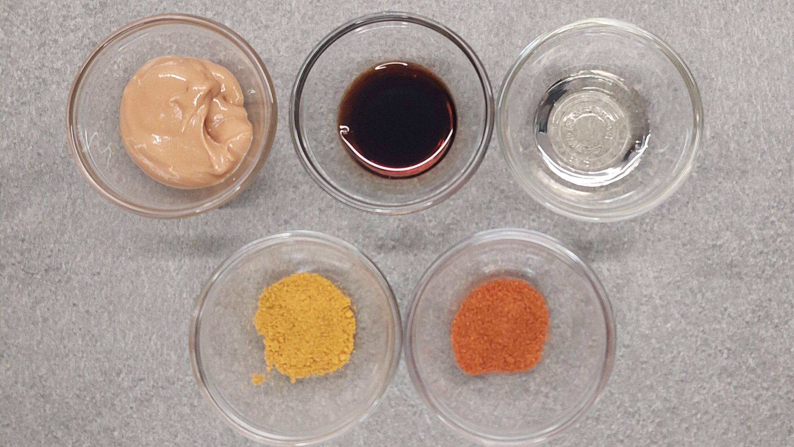 Zutaten für die einfache Erdnusssoße: Erdnussbutter, Sojasoße. Agavendicksaft, Curry und Paprika